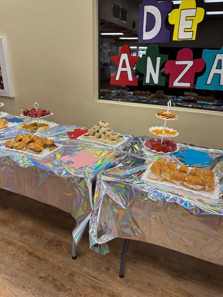 A table of homemade treats under a De Anza sign.