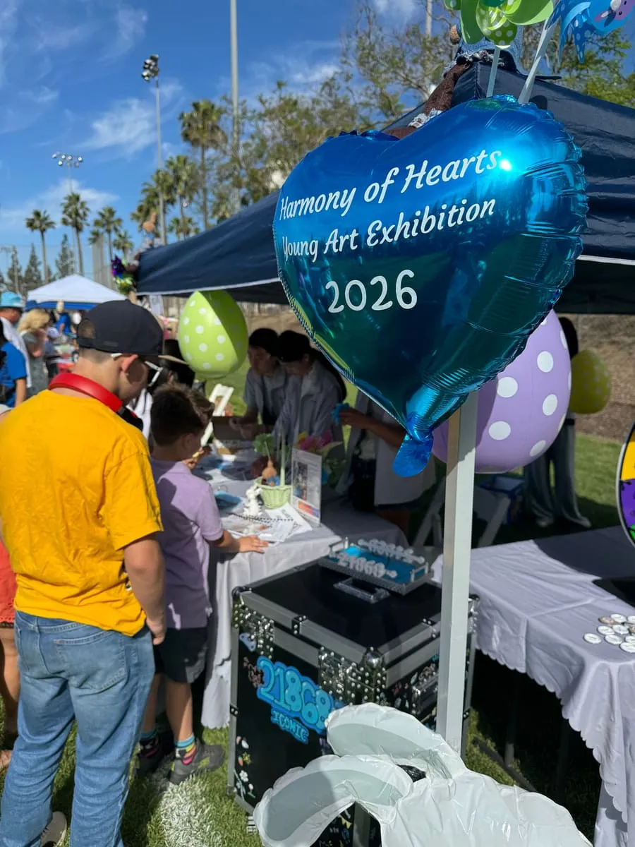 A Harmony of Hearts 2026 heart balloon floats over the Polaris booth at an outdoor festival.