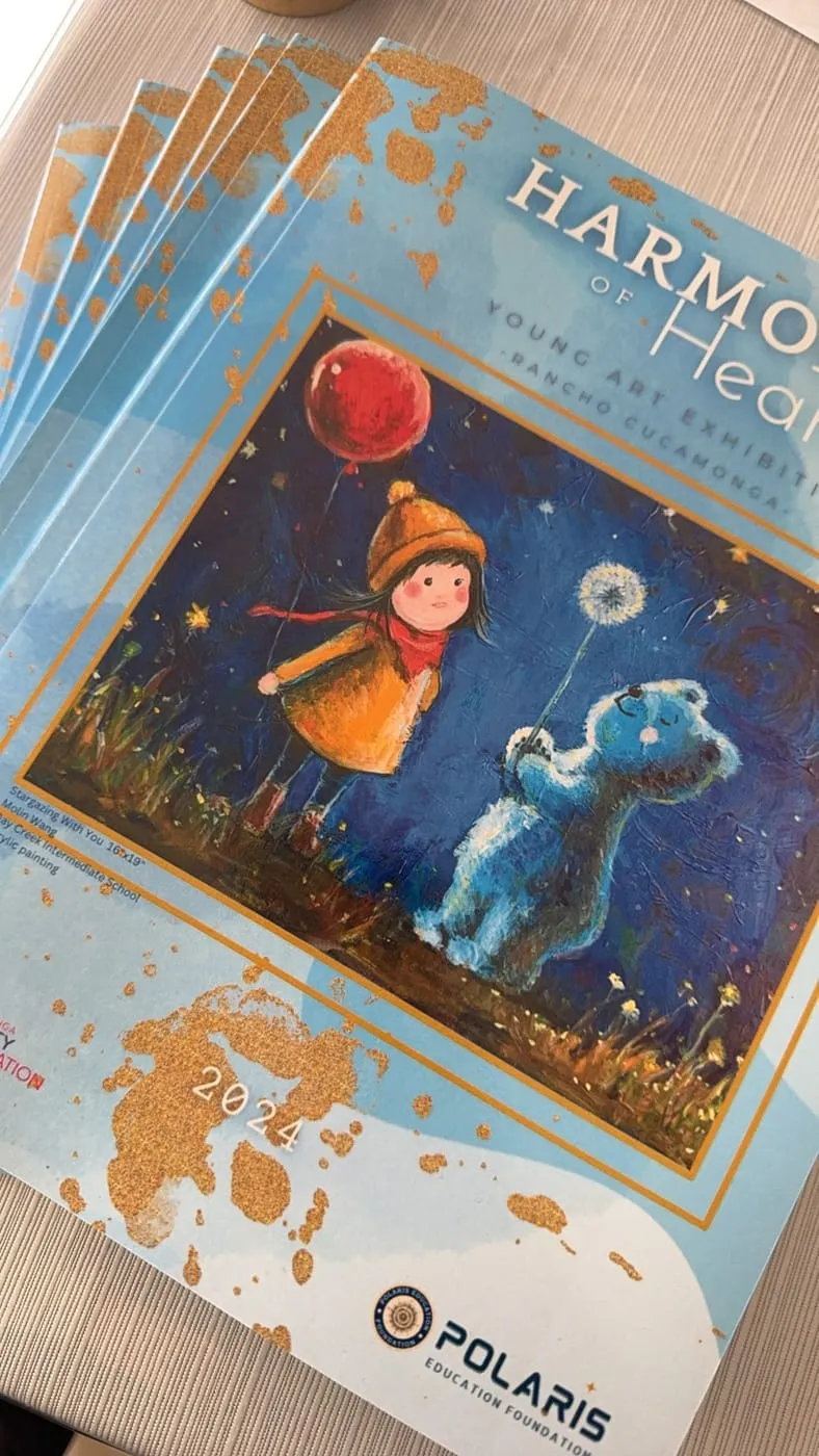The 2024 artbook, its cover showing a painting of a child with a red balloon beside a blue bear.