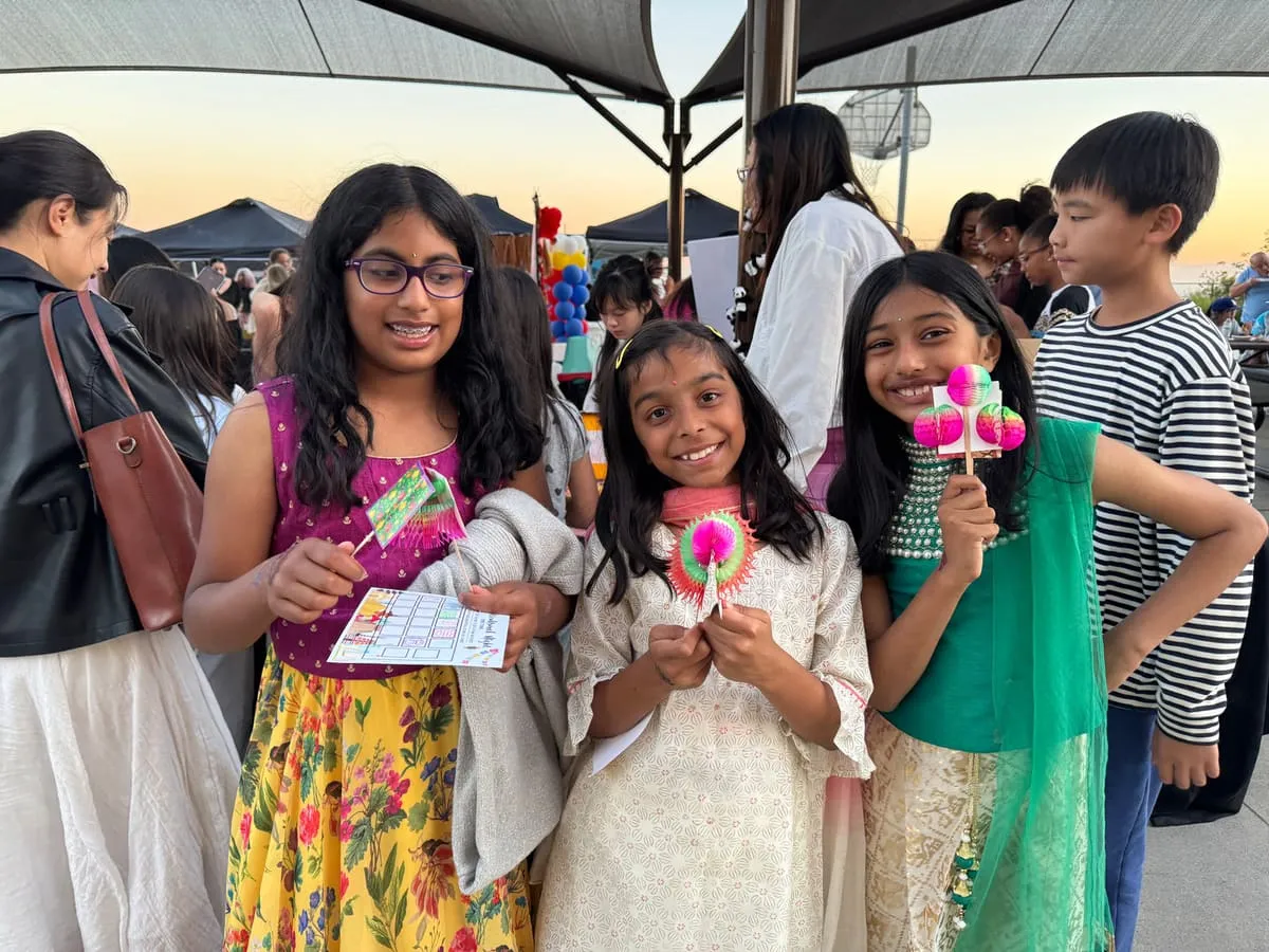 Girls at an evening festival show off the crafts they made.